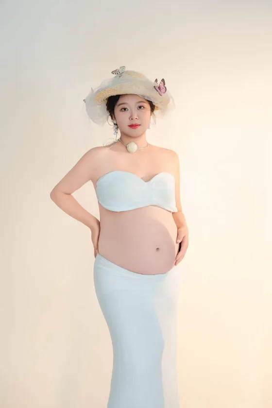 徐淑颖戴蝴蝶装饰帽子的暖色孕照