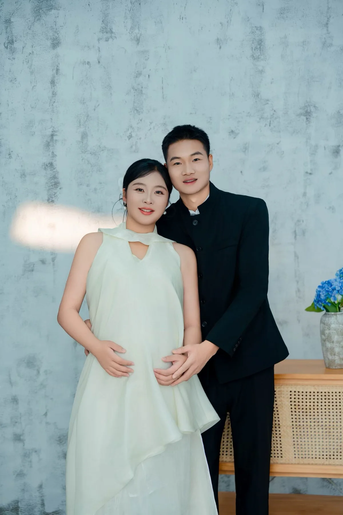 徐淑颖与李国荣相依站立，双手轻放在孕肚上